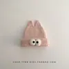 Gorro de inverno infantil, quente e espesso, com um design engraçado apresentando olhos grandes, estilo de puxar e proteção para as orelhas, adequado para meninos e meninas, e estiloso