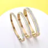 Suministro de fábrica transfronterizo en stock al por mayor joyería acero de titanio chapado en oro hilera única circonita cierre de bayoneta pulsera moda pulsera para pareja