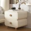 Mesita de noche de color crema con acolchado suave, esquinas redondeadas, doble cajón y patas de madera maciza, un mueble de almacenamiento simple y práctico para el dormitorio