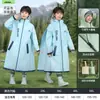 Capa de chuva infantil para meninos e meninas, impermeável de corpo inteiro, especialmente projetada para alunos do ensino fundamental usarem na escola, com espaço para mochila