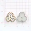 ABS estilo coreano blanco y negro trébol de cuatro hojas DIY pegamento de crema accesorios para joyería pequeños accesorios pendientes pasador de pelo agujero material para zapatos
