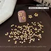 Pedras de strass para nail art em zircônia cúbica na cor champanhe, com zircônias cúbicas brilhantes em formato de gota, grandes e pequenas, arranjadas em um design de flor de cinco pétalas