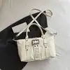 Bolso de motocicleta con remaches de diseño único para mujer, bolso de mano con hebilla de cinturón negra, moderno y versátil, adecuado para ir al trabajo, bolso de hombro o bolso cruzado.