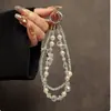 Correa de teléfono de cristal de perlas lujosa y elegante con un llavero de oso con forma de corazón de doble capa de moda y accesorio para bolso