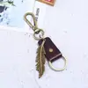 Chaveiro de Pena de Liga de Bronze e Couro, Estilo Retro Artístico, Acessório Unissex, Pequeno Presente Criativo Vintage de Couro Genuíno