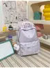 Mochila pequeña, simple, de color sólido con bordado de letras texturizado, diseñada para estudiantes mujeres, adecuada para la escuela y el uso diario, ligera y reduce la carga en los hombros