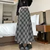 Foto real de falda de lana a cuadros estilo coreano de longitud media para otoño/invierno 2026, con un bajo amplio que cubre las caderas y estiliza.