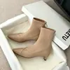 Look suave de estilo coreano con abrigo, botas cortas de gamuza de cuero nude empalmadas y ajustadas, invierno 2026, botines de tacón medio grueso con punta para mujer