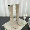 Botas western de bico fino e salto alto até o joelho, outono e inverno de 2026, com saltos agulha de camurça estilo retrô e fivelas de metal