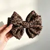 En stock al por mayor Clip de plátano con lazo de estampado de leopardo retro coreano clip vertical de tela plisada accesorio para el cabello suave y elegante