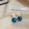 Pendientes colgantes azules de alta calidad con diseño de nicho, pendientes acrílicos florecientes con temperamento blanco moderno.