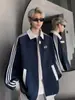 Jaqueta Casual Solta Estilo High Street Sudadora Color Block com Três Listras Tendência para Homens Inverno 2025 Novo Estilo Americano