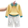 Ropa infantil coreana 2026 colección otoño/invierno nueva: suéter de punto amarillo con cuello alto texturizado y pantalones blancos casuales de pierna recta
