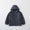 Nuevo cortavientos con capucha de bloques de color para otoño y primavera para niños, elegante y de corte holgado, adecuado para niños mayores, y diseñado para actividades al aire libre, ofreciendo protección contra el viento y una estética de ropa de trabajo.