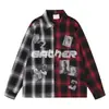 Camisa de manga larga holgada para hombre con un patrón de cuadros vintage, que presenta un diseño de cuadros de contraste blanco y negro y rojo y negro en los lados izquierdo y derecho.