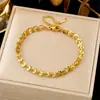 Pulseira feminina de aço titânio, lisa e elegante, com design moderno e sofisticado, em tom dourado, com trevo de quatro folhas e padrão cruzado.