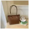Bolsa tote feminina casual retrô de design requintado estilo coreano 2026 cor sólida com pingente nova moda tendência de ombro único