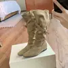 Botas altas de punta con interior elevador de altura, tacón de 4 cm, diseño de nicho y detalles fruncidos.