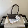 Bolso tipo baguette de lunares de alta gama estilo coreano para mujer, nuevo modelo de verano 2026, bolso versátil de hombro y axila de lujo ligero para el día a día.
