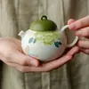 Juego de té de cerámica pintado a mano bajo vidriado con motivos de mariposas y flores, que incluye un gaiwan, tetera, taza de té, platillo, posavasos y vaso de agua