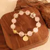 Pulsera bicolor de cristal azul natural y cristal rosa con diseño de oso y rosa, una pulsera blanca de lujo ligero y estilo antiguo fresco.