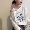 Nueva colección de otoño temprano 2026 para mujer: Camiseta holgada de manga larga con escote asimétrico, diseño de hombros descubiertos y estampado de letras