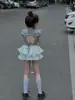 Roupa Infantil 2025 Verão Estilo Coreano Moda Feminina Camiseta com Recorte nas Costas e Nó Manga Curta Doce Saia Plissada Curta