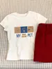 Camiseta de Hombro Recto Estampada Inspirada en el Diseño para Mujer, Verano 2026, Estilo Coreano, Top Suelto Casual Adelgazante, Camiseta Cómoda de Algodón Puro, Moderna