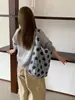 Nova coleção outono/inverno: bolsa de ombro clássica com blocos de cor e bolinhas grandes. Versátil, elegante e perfeita para o uso diário, esta bolsa tote pode ser carregada sob o braço e é ideal para o trajeto diário.