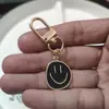 E-commerce transfronteiriço liga de cor gota rosto sorridente chaveiro galvanizado ouro expressão irregular bolsa pingente acessórios