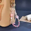Nuevo colgante de teléfono de doble cadena con un toque de alta gama, cuentas luminosas de flor de cerezo, correa de muñeca para teléfono, charm para bolso, pequeño regalo para mujeres