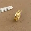 Anel versátil para o dia a dia com design refinado, apresentando um fecho estilo cadeado e detalhes vazados, oferecendo um visual único e estiloso para mulheres.