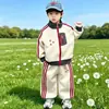 Conjunto de roupas infantis para meninos e meninas, novo estilo outono 2026, jaqueta com zíper e design patchwork, calça esportiva casual, conjunto infantil de duas peças