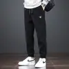 Calça Nova Masculina da Moda para Primavera e Outono Marca Tendência Solta Versátil Elástica Esportiva Jogger Calça de Moletom de Veludo Cotelê Bordada