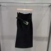 Coleção Outono/Inverno 2026 transfronteiriça: saia midi preta de cintura alta com detalhes de fivela metálica, apresentando uma fenda alta e um design simples e versátil adequado para o trabalho ou para o dia a dia