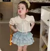 Ropa para Niños 2026 Verano Nuevo Estilo Niñas Coreana Bordada Cuello de Muñeca Camisa de Algodón Falda a Cuadros con Capas Pantalones