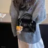 Bolso de mano para mujer estilo commuter, minimalista y sutilmente lujoso para el otoño de 2026, con un diseño afelpado, versátil para llevar al hombro o cruzado.