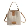 Bolso de paja tipo cubo nuevo estilo vacación de verano en la playa 2026, con un fresco diseño de patchwork en colores contrastantes y una textura tejida simple, un bolso para mujer