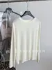 Nuevo modelo de otoño temprano 2026, camiseta básica de manga larga con hebilla metálica y costura central en la espalda, hecha de lana de oveja suave y agradable para la piel