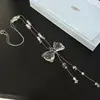 Collar con borla de lazo de cristal transparente súper etéreo para mujer, cadena de suéter versátil de alta gama con cuentas de perlas de nicho de lujo ligero