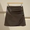 Saia irregular de couro PU marrom para mulheres, estilo outono e inverno, adequada para combinar com botas, plus size, estilosa, justa com corte em A, curta