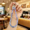 Nuevo Colgante de Cristal Super Brillante Acrílico Bolsa Auriculares Bluetooth Colgante Pequeño Llavero de Coche Cadena para Teléfono Móvil Venta al por Mayor