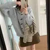 Nuevos estilos de otoño e invierno de Japón y Corea: suéteres suaves, holgados y con capucha, prendas de abrigo para mujer, y tops de punto de manga larga con un estilo relajado, casual y botones tipo cuerno