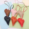Nuevo colgante de bolsa creativa de cuero con forma de corazón de melocotón, adornos de PU de amor exquisitos, pequeño regalo, accesorios de cuerda para mano de ropa, fabricantes