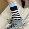 Calcetines a rayas con bloques de color y borde enrollado, un diseño de nicho para mujer, con un aspecto de doble capa y superpuesto, de longitud hasta la mitad de la pantorrilla, hechos de algodón para abrigar, y un estilo moderno y con volantes.