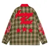 Camisa de manga larga a cuadros azul marino para hombre con cuello rojo, con un diseño de estilo callejero punk oscuro con parches de llamas y estrellas, y un corte holgado.