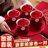 Um conjunto de xícaras de chá de casamento, incluindo um par de tigelas de chá e pauzinhos vermelhos e festivos, perfeito para servir chá durante a cerimônia de casamento.