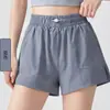 Conjunto de atuendo de yoga para mujer con un ambiente brumoso y relajado, que presenta un top elegante y versátil de corte holgado con un escote asimétrico y shorts con cintura elástica anti-exposición