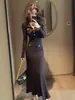Elegante vestido de estilo francés para ocasiones importantes, con una cintura estilizada, combinado con un vestido de punto color café para otoño