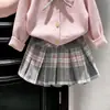 Estilo Coreano Meninas Outono/Inverno 2026 Novo Conjunto de Duas Peças: Suéter de Tricô Rosa com Laço e Saia Plissada Xadrez Infantil